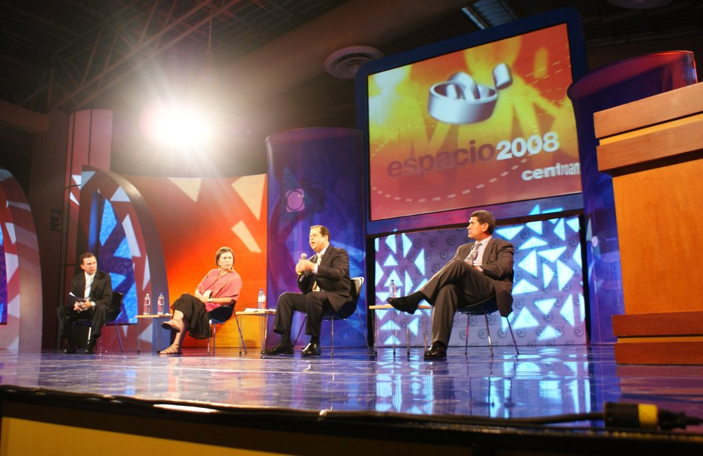 Panel discussion on the Espacio 2008 Centroamérica stage with the event screen behind the speakers